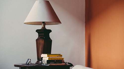 table lamp pile of books beside brown table lamp book